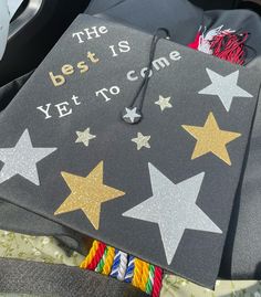 a graduation cap that says the best is yet to come with gold stars on it