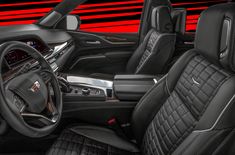 the interior of a car with black leather seats and red stripes on the wall behind it