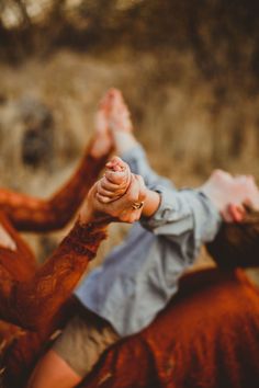 two people holding hands in the air with their legs spread out and one person reaching for something