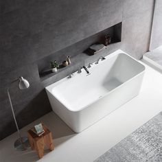 a large white bath tub sitting on top of a floor next to a wooden stool