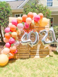 a large number sign made out of wooden pallets with balloons