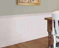 a dining room table and chairs with a painting on the wall