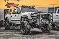 a white truck parked in front of a taco shop