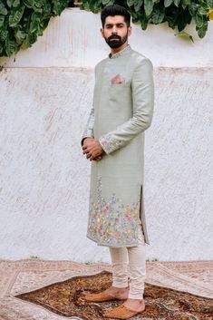 a man standing on top of a rug wearing a suit