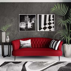 a red couch sitting next to two black and white pictures