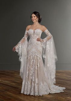 a woman in a wedding dress standing on a wooden floor with her hands on her hips