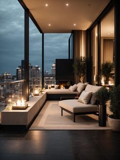 an outdoor living area with couches and candles on the windowsill at night time