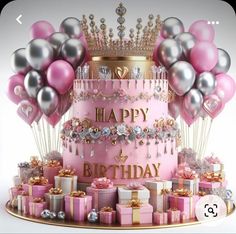 a pink birthday cake surrounded by presents and balloons