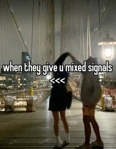 two people standing on a bridge with the words when they give u mixed signals