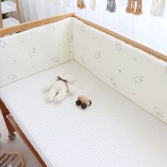 a baby crib with a stuffed animal on the bottom and an empty mattress underneath it