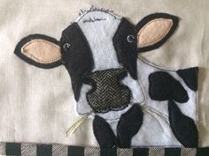 a close up of a cow made out of fabric on a piece of cloth with black and white stripes