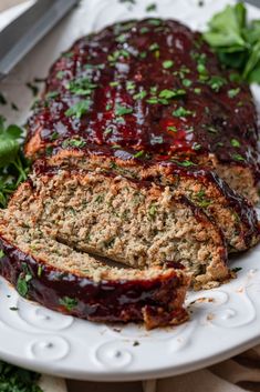 sliced meatloaf on a white plate with parsley