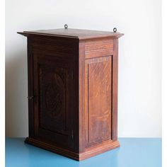 an old wooden clock on a blue table