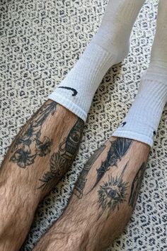 the legs of a man with tattoos on them