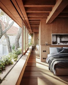 a bedroom with wooden walls and floor to ceiling windows