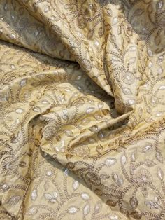 the fabric is very soft and shiny, it looks like an intricate pattern on gold