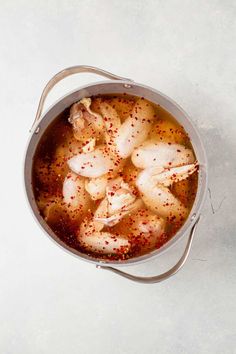 a pot filled with chicken and spices on top of a table