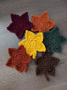 six crocheted leaves on a wooden surface