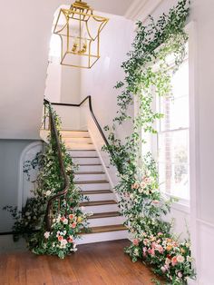 the stairs are decorated with flowers and greenery