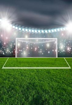 a soccer goal in the middle of an empty field at night with bright lights on it