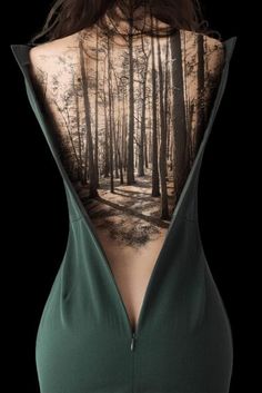 the back of a woman's body with trees on it