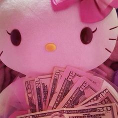 a pink hello kitty stuffed animal holding money