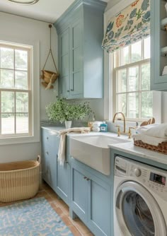 a laundry room with blue cabinets and a washer and dryer