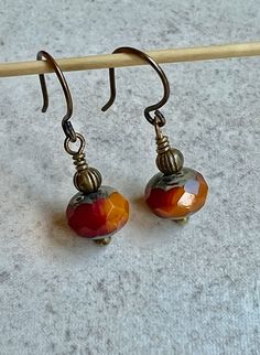 "tiny red orange earrings   small boho dangle earrings   1\" czech glass earrings These faceted Czech glass beads are both deep red and mango orange with a Picasso coating at their tops and bottoms. I positioned the beads so both colors are visible from the front. Each bead is topped with a tiny antiqued brass bead. Small hook ear wires are antiqued brass. Length of earrings from top of ear wires is 1\". Glass bead measures 6x8mm. You can enter my shop here: gypsydangles.etsy.com" Jewelry Board, Orange Earrings, Earring Designs, Jasper Earrings, Small Boho, Earring Ideas, Jewelry Boards, Bohemian Earrings, I Love Jewelry