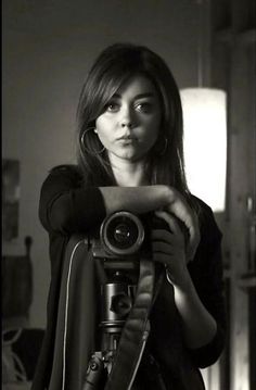 black and white photograph of woman holding camera