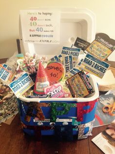 a basket filled with candy and candies sitting on top of a wooden table next to a sign