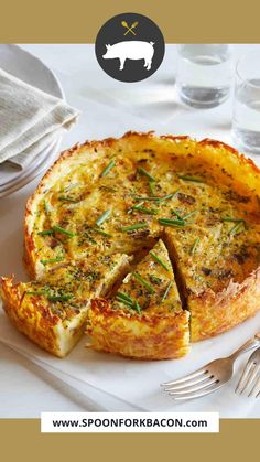 a quiche on a plate with a fork and glass of water in the background