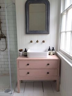 a bathroom with a sink, mirror and bathtub in the shower area next to a window