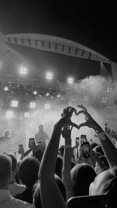 people are holding their hands up in the air at a concert