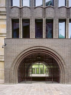 an arched entrance to a brick building with lots of windows