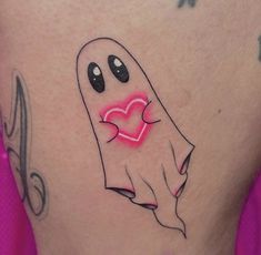 a woman's stomach with a ghost holding a heart tattoo on the side of her thigh