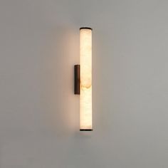 a wall mounted light on the side of a white wall