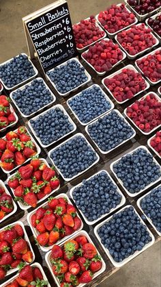 fresh strawberries and blueberries for sale at a farmers market