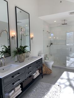 a bathroom with two sinks and mirrors on the wall next to a toilet, shower, and bathtub