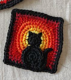 a crocheted square with a black cat on it