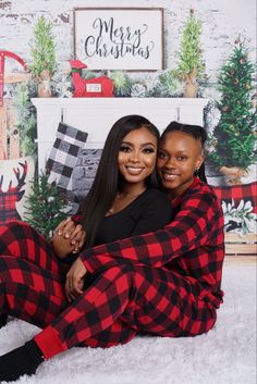 two women sitting on the floor in matching plaid pajamas, one is hugging the other's chest