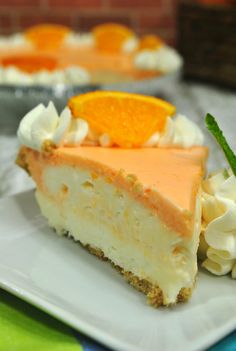 a slice of cheesecake on a plate with an orange garnish and whipped cream