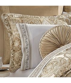 a close up of a bed with many pillows