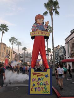 a sign that says play pals toys in front of people walking down the street