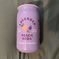 lavender peach soda can sitting on a bed