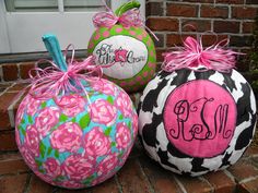 three decorative pumpkins with monogrammed designs on them