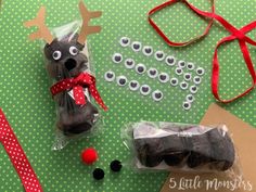 an assortment of christmas treats and decorations on a green table with red ribbon, reindeer nose