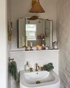 a white sink sitting under a bathroom mirror next to a wall mounted faucet