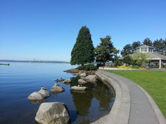 there is a large body of water with rocks in the foreground and houses on the other side