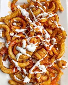 a white plate topped with onion rings covered in sauce