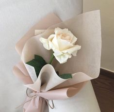 a bouquet of flowers is tied to the back of a couch cushion with ribbon on it